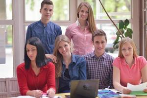 Lycklig tonåren grupp i skola foto