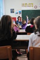 Lycklig lärare i skola klassrum foto