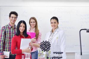 Lycklig tonåren grupp i skola foto