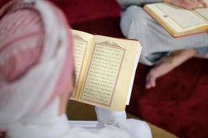 två muslim människor i moské läsning quran tillsammans begrepp av islamic utbildning foto