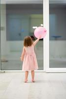 söt liten flicka spelar med ballonger foto