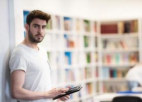 studerande i skola bibliotek använder sig av läsplatta för forskning foto