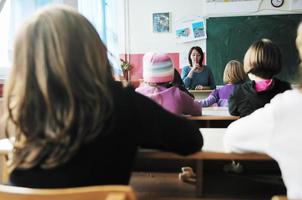 Lycklig lärare i skola klassrum foto