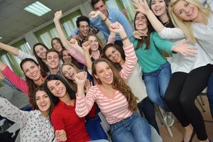 Lycklig tonåren grupp i skola foto