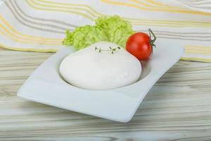 mozzarella i en skål på trä- bakgrund foto