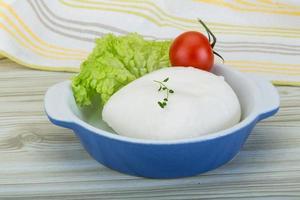 mozzarella i en skål på trä- bakgrund foto