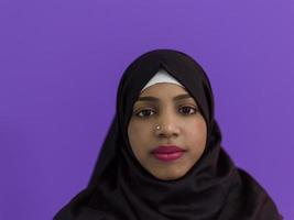 porträtt av afrikansk muslim kvinna bär hijab och traditionell muslim kläder Framställ i främre av lila bakgrund foto