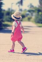 liten flicka springer i sommarparken foto
