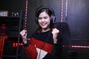 ung kvinna professionell banderoll och gamer med headsetet spelar uppkopplad video spel foto
