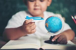 porträtt av pojke med en flygplansmodell i klassrummet foto