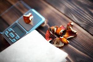 torkade bitar av svampflugsvamp på bordet med fjäll. mätning av mikrodos, mikrogram psykedelisk, terapeutiskt narkotisk substans i giftig amanita muscaria. mikrodosering, psykotropisk foto