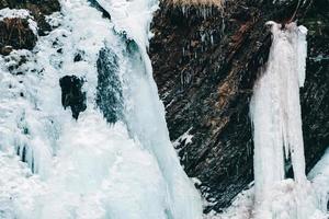 vinter vattenfall med fruset vatten och snö foto