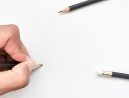 hand som håller en svart penna redo att skriva något på papper foto