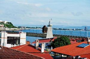 staty av helgon nicholas med väderkvarn i de gammal stad. de gammal stad av nesebar, bulgarien. foto