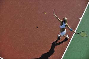 ung kvinna spela tennis utomhus foto