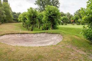 golfbana med gräs och moln på himlen foto