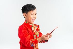 liten vietnamese pojke innehav röd omsluter för tet. de ord betyda dubbel- lycka. den är de gåva i lunar ny år eller tet Semester på isolera bakgrund foto