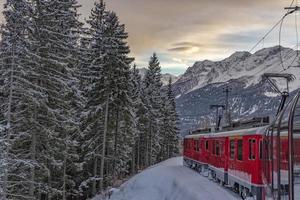 röd tåg i de snö i swiss alps foto