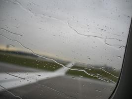 regn droppar på flygplan fönster foto