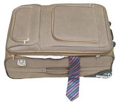 på glänt textil- resväska med manlig slips isolerat foto