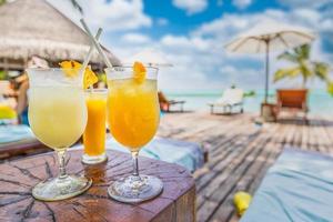 cocktail glasögon på slå samman, strand sida. solig tropisk poolen med blå ljus himmel. rekreations frihet, sorglös begrepp, resa semester. kall drycker med suddig tropisk simning slå samman. exotisk foto