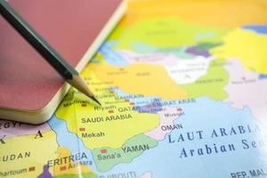 vald fokus saudi arabien på en värld Karta med bok och penna. foto