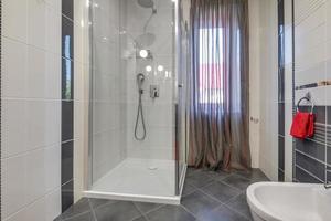 toalett och detalj av en hörnduschkabin med väggmonterad duschfäste foto