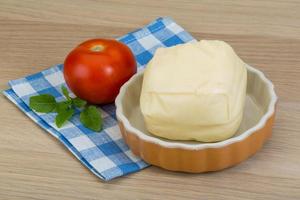 mozzarella ost i en skål på trä- bakgrund foto
