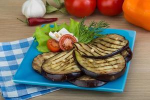 grillad aubergine på de tallrik och trä- bakgrund foto