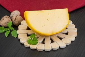 gul runda ost på trä- bakgrund foto