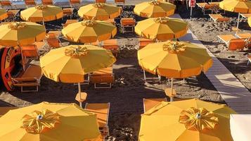 textur av paraplyer på de sand av de strand spotorno, i Västra liguria under en sommar morgon- i 2022 foto