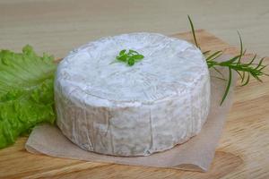 Camembert ost på trä- styrelse och trä- bakgrund foto