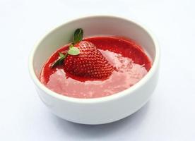 jordgubb puré i en skål på vit bakgrund foto