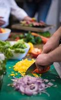kocken händer skär färska och läckra grönsaker foto