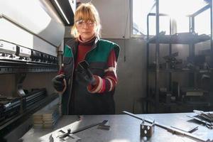 kvinna arbetssätt i en modern fabrik och framställning materia för en cnc maskin. foto