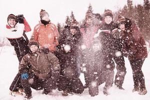 grupp av ung människor kasta snö i de luft foto