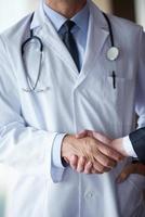 läkare handslag med en patient foto