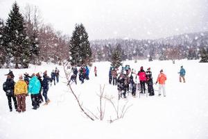 grupp av ung människor framställning en snögubbe foto