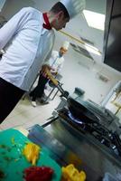 kock i hotell kök förbereda mat med brand foto