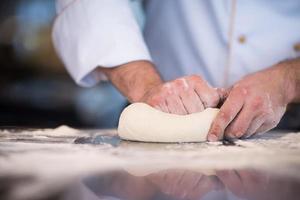 kock händer framställning deg för pizza foto