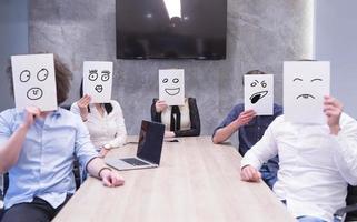 börja företag team innehav en vit papper över ansikte foto