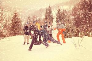 grupp av ung människor har roligt i skön vinter- landskap foto