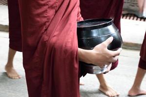 burmesisk munk som bär tiggbunke