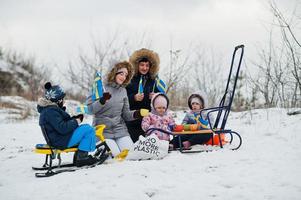 skandinavisk familj med Sveriges flagga i svenska vinterlandskap. foto