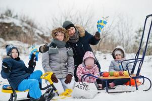 skandinavisk familj med Sveriges flagga i svenska vinterlandskap. foto