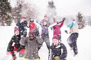 grupp av ung människor kasta snö i de luft foto