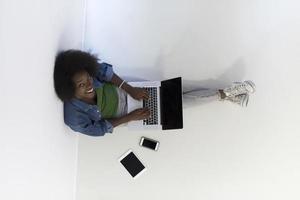 afrikansk amerikan kvinna Sammanträde på golv med bärbar dator topp se foto