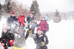 grupp av ung människor kasta snö i de luft foto