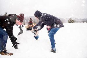 grupp av ung människor framställning en snögubbe foto