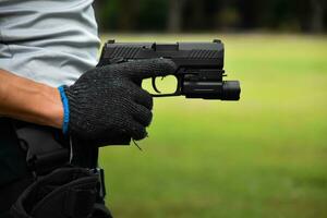 pistol innehav i händer av beväpnad på de skytte klubb, mjuk och selektiv fokus på pistol, begrepp för skytte sport, livvakt, säkerhet Träning, maffia, gangsters och själv skydd. foto